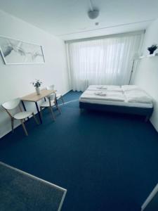 um quarto com uma cama, uma mesa e cadeiras em Apartmány Bryksova em Praga