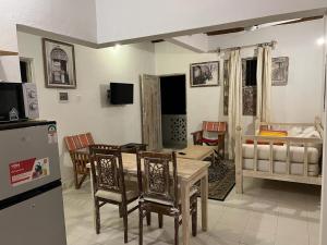 eine Küche und ein Wohnzimmer mit einem Tisch und Stühlen in der Unterkunft Beytsalaam Apartments in Lamu