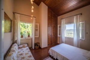 1 dormitorio con cama y ventana en Riza Stone Cottage, romantic house, pet friendly en Vátos