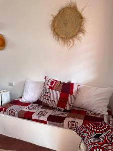 Una cama con manta y almohadas. en Habibi B&B en Uroa