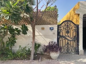 um portão para uma casa com uma árvore em frente em Tropicana Guestroom 7 min walk from the beach em Dubai