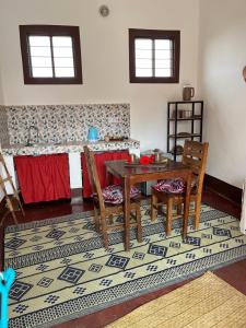 ein Esszimmer mit einem Tisch und Stühlen auf einem Teppich in der Unterkunft Habibi B&B in Uroa