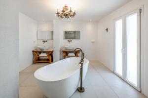 La salle de bains est pourvue d'une baignoire, de deux lavabos et d'un lustre. dans l'établissement Kallisti Paros, à Náoussa