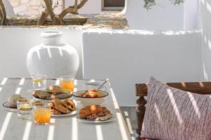 uma mesa com pratos de comida e copos de sumo de laranja em Kallisti Paros em Naousa