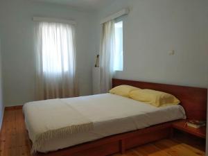 a bedroom with a large bed with a window at Ευχάριστο σπίτι με ωραίο κήπο in Pylos