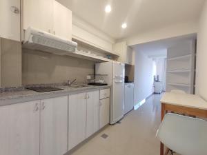una cucina con armadietti bianchi e frigorifero bianco di DELFINA suites 2A a La Rioja