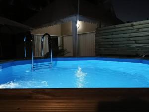 uma grande piscina azul à noite em Bungalow Marie em Saint-François