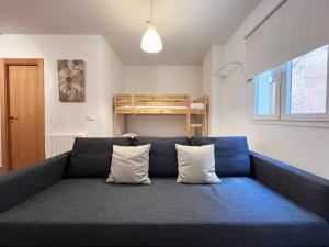 niebieska kanapa z 2 poduszkami w pokoju w obiekcie Apartamentos Sierra Nevada 3000 w mieście Sierra Nevada