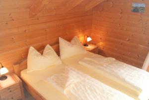 Ce lit se trouve dans une chambre en bois dotée de 2 oreillers. dans l'établissement Großes Ferienhaus mit 5 Schlafzimmer & 4 Bäder, à Pöllauberg