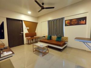 a living room with a couch and a ceiling fan at Horizon Apartment 1BHK in Pune