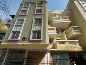 a tall building with white windows on it at Horizon Apartment 1BHK in Pune