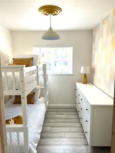 una camera da letto con un letto a castello e una scrivania di Stylish 3 bedroom seaside escape - newly renovated a Paignton