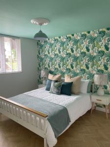 a bedroom with a large bed with a floral wallpaper at Stylish 3 bedroom seaside escape - newly renovated in Paignton