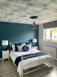 1 dormitorio con 1 cama con pared azul en Stylish 3 bedroom seaside escape - newly renovated, en Paignton