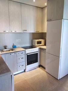 a kitchen with white appliances and a white refrigerator at Trinity apartman in Bar