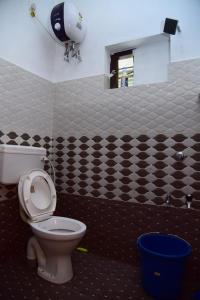 a bathroom with a toilet and a black and white tiled wall at MOUNTAIN VIEW HOLIDAY HOME ( A M HOMESTAY) in Kalpetta