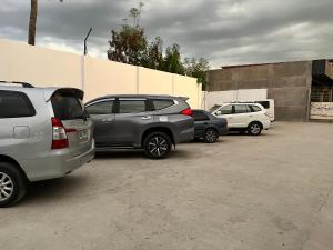 een groep auto's geparkeerd op een parkeerplaats bij Dampa Poolside Events & Accommodation 
