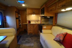 a living room with a couch and a kitchen at Luxury American RV with Hot Tub in West Chiltington