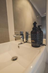 a soap dispenser sitting on a bathroom sink at Cape Town Surf Hostel & Lodge in Cape Town