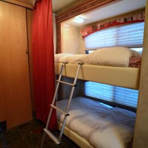 two bunk beds in a room with a window at Luxury American RV with Hot Tub in West Chiltington