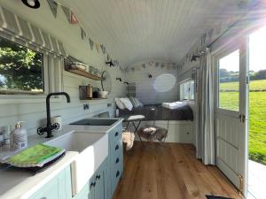a kitchen in a tiny house with a sink and a bed at Glebe Farm B&B in Kingsbridge