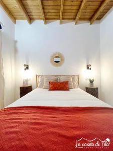um quarto com uma cama grande e um cobertor vermelho em La Casita de Tila em Ifonche