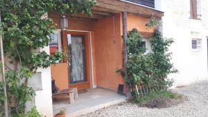 une entrée à une maison avec une porte orange dans l'établissement la ferme de cherevie, à Saint-Bris-le-Vineux