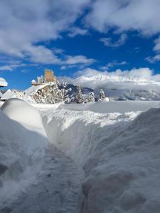 einen Schneehaufen mit einem Schloss im Hintergrund in der Unterkunft Apart Hotel Neier in Ladis