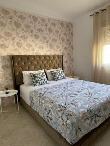 1 dormitorio con 1 cama con colcha de flores en Joli appartement au centre d'Oujda, en Oujda