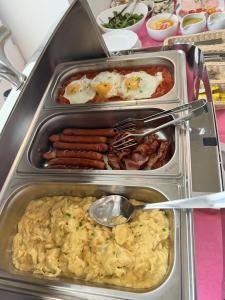 a tray of breakfast food with eggs and sausage at Apartamenty Efekt 72 in Gdynia
