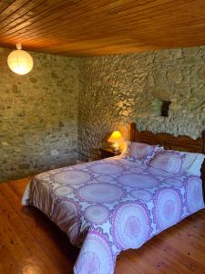1 dormitorio con 1 cama en una pared de piedra en Can Carreras, en Monells