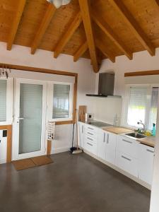 eine Küche mit weißen Schränken und einer Holzdecke in der Unterkunft A Casa do Portal in Campo Lameiro