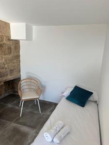 ein Schlafzimmer mit einem Bett und einem Stuhl in der Unterkunft A Casa do Portal in Campo Lameiro