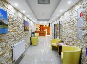 un restaurante con sillas amarillas y una pared de piedra en Aparthotel Adler, en Cracovia