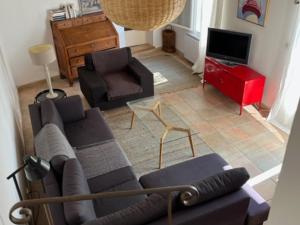 ein Wohnzimmer mit einem Sofa, einem Stuhl und einem TV in der Unterkunft Maison La Flotte, 5 pièces, 6 personnes - FR-1-544-3 in La Flotte