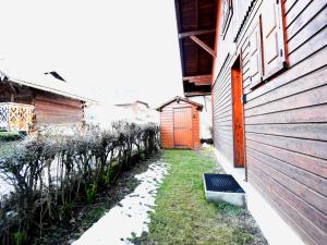 an alley with a red door next to a building at Chalet Individuel avec Jardin à 600m du Centre de Morzine – 2 Chambres, Wifi, Parking - FR-1-524-93 in Morzine