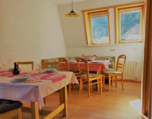 a dining room with tables and chairs and windows at Appartement Jakalar in Vils