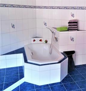 y baño con bañera y azulejos azules. en Appartement Jakalar en Vils