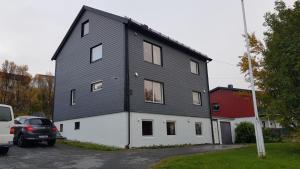 ein schwarzweißes Haus mit einer roten Scheune in der Unterkunft Nord Hus Service AS, Nr 1 in Havøysund