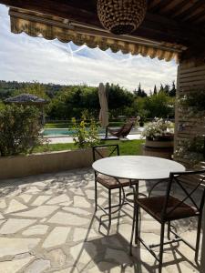 a patio with a table and chairs on a patio at CARLIN Ferme Haute Prairie in Lourmarin