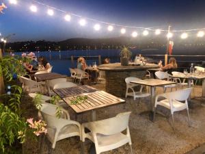 a patio with tables and chairs and a view of the water at Studio Bord de Mer et VUE sur MER WIFI OFFERT in La Seyne-sur-Mer