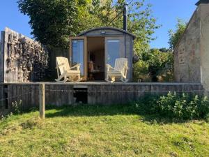 a tiny house with two chairs on a porch at The Goods Wagon, private garden and stunning views in High Buston