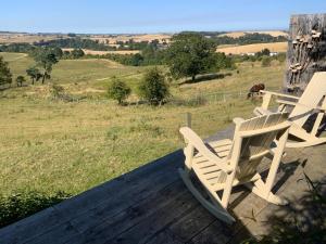 two chairs sitting on a deck with a view of a field at The Goods Wagon, private garden and stunning views in High Buston