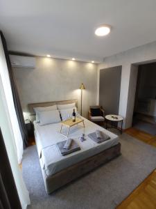 a bedroom with a large bed and a table at KaLuMa in Belgrade