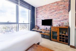 a bedroom with a brick wall and a bed and a television at Central in Istanbul