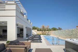 a view of the pool and patio of a villa at Ivory Villa, with effusive design, By ThinkVilla in Perama