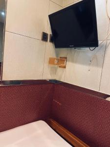 a tv on the wall of a room with a bed at 安捷賓館 Famous Guest House in Hong Kong