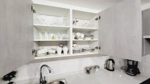 a kitchen with white shelves with dishes on them at Casa Tranquila in Playa de San Juan
