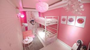 een roze kamer met een stapelbed en een stoel bij Spring Light in Seoul