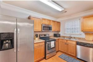 a kitchen with stainless steel appliances and wooden cabinets at Beautiful Cozy 3-Bedroom Townhome Retreat in Atlanta